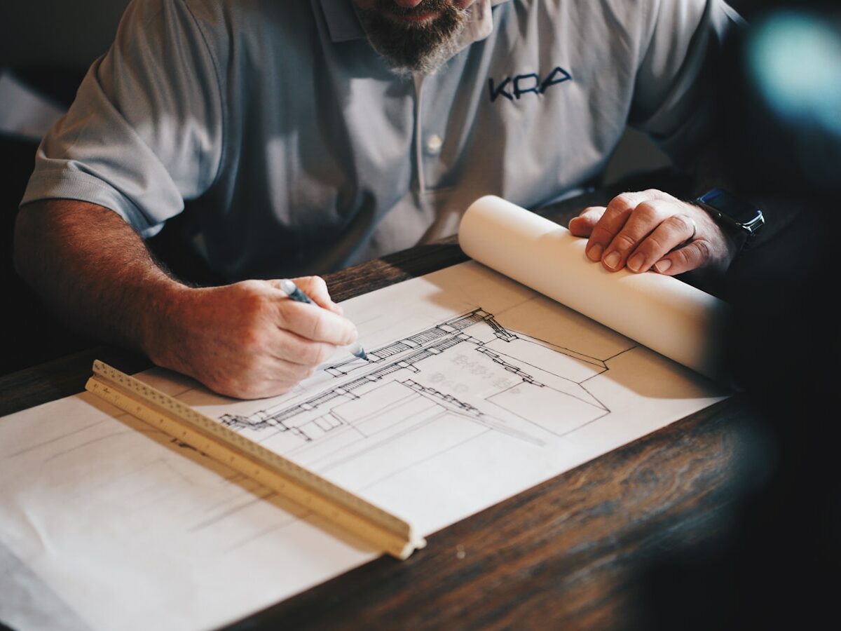 An architect working on a draft with a pencil and ruler